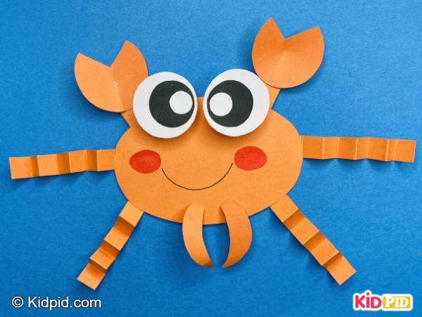 Smiling orange paper crab with curly legs